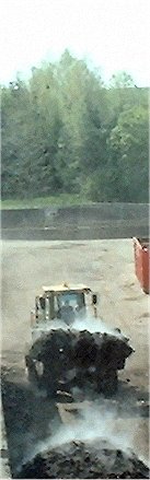 Manure being moved by machine.