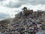 A landfill compactor on a skyline of waste
