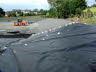 A progression of landfill lining layers on a slope